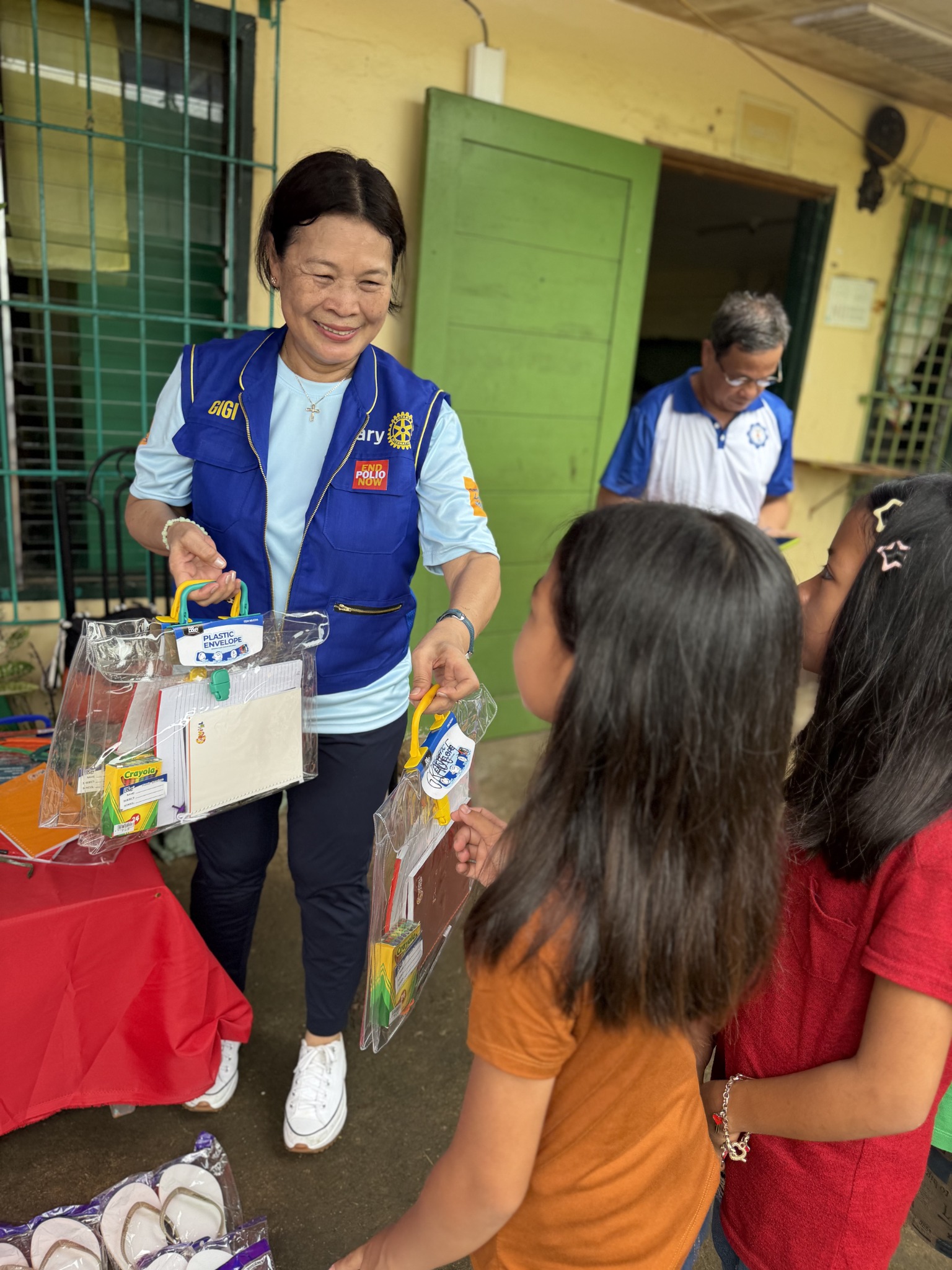 Rotary Club of Mandaluyong Central volunteer distributing school supplies